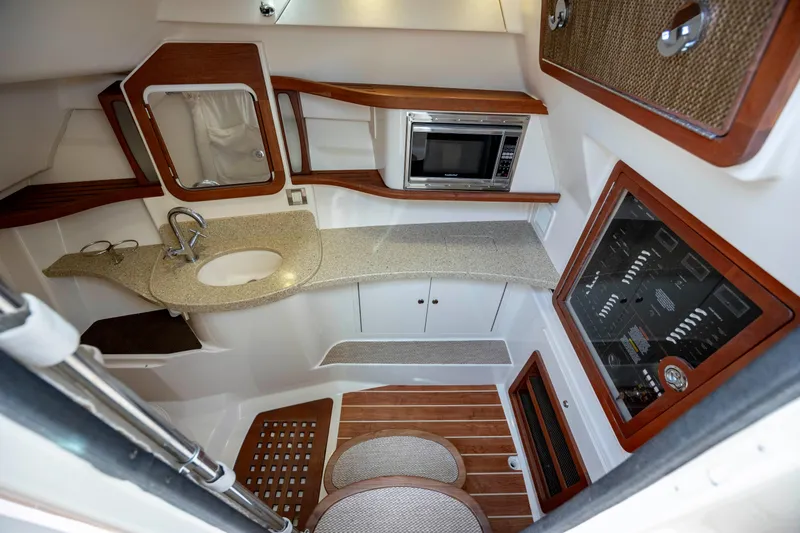 Slide: The Image of 2015 Grady-White Freedom 375 cabin interior with kitchenette, sink, and wood accents. - 36