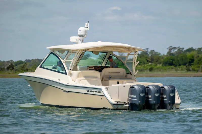 Slide: The Image of 2015 Grady-White Freedom 375 boat cruising on water with triple Yamaha engines. - 5