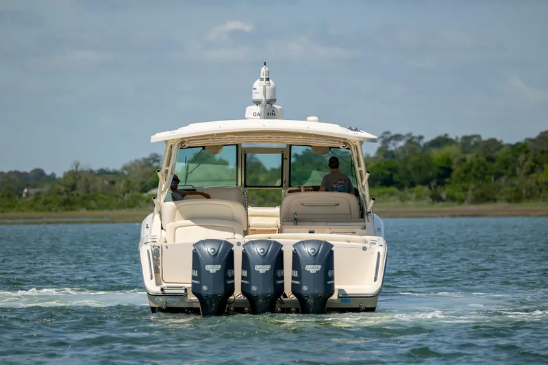 Slide: The Image of 2015 Grady-White Freedom 375 boat with triple outboard engines on a calm waterway. - 6