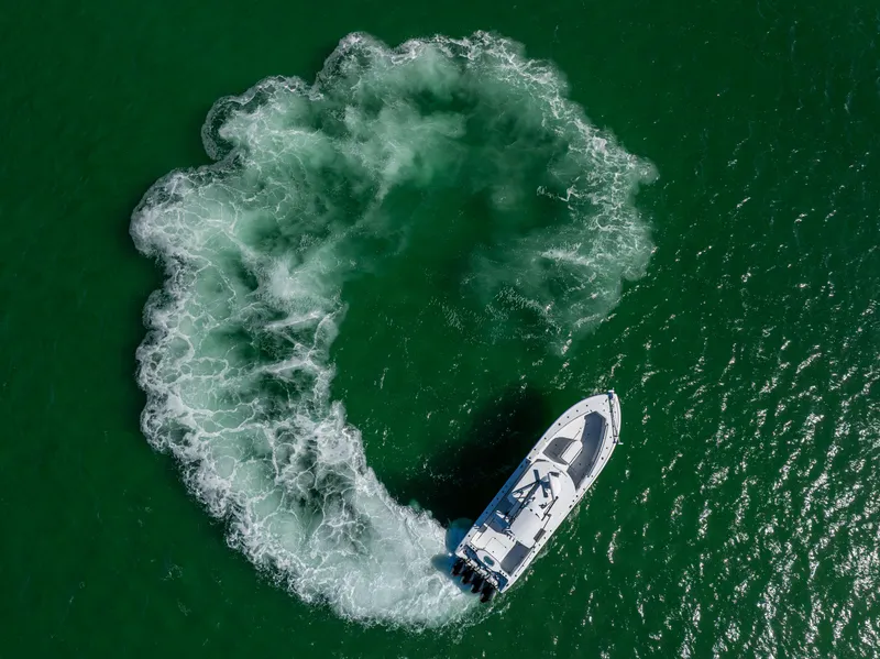 Slide: The Image of Aerial view of 2023 Yellowfin 39 Offshore boat making a circular wake in green water. - 12
