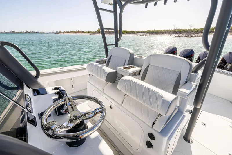 Slide: The Image of 2023 Yellowfin 39 Offshore boat interior with dual seats and steering wheel, overlooking the ocean. - 23