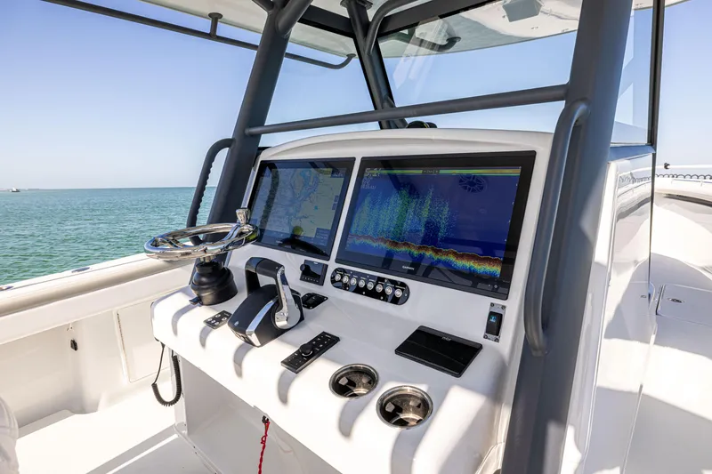 Slide: The Image of 2023 Yellowfin 39 Offshore boat dashboard with dual screens and controls, ocean view. - 25