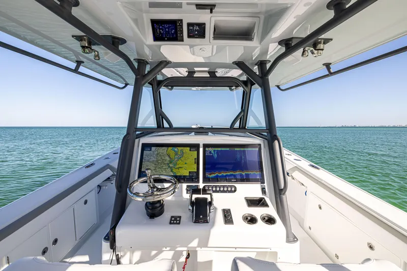 Slide: The Image of 2023 Yellowfin 39 Offshore boat dashboard with navigation screens on open water. - 26