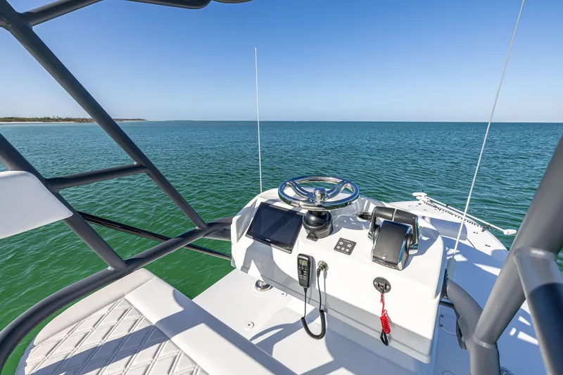 Slide: The Image of 2023 Yellowfin 39 Offshore boat helm with ocean view, featuring modern controls and steering. - 40