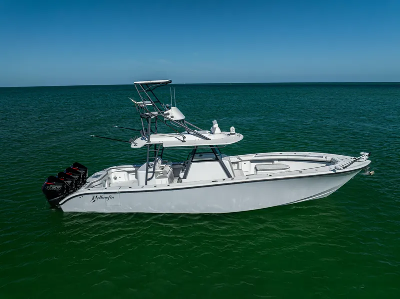 Slide: The Image of 2023 Yellowfin 39 Offshore boat on calm green water under clear blue sky. - 6
