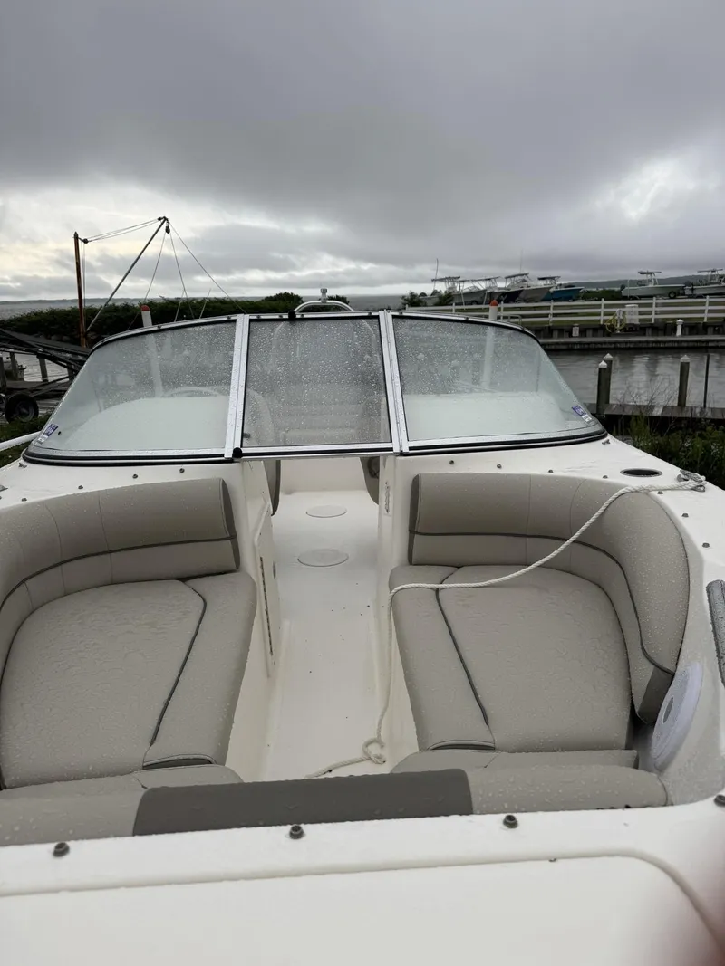 Slide: The Image of 2021 Key West 203 DFS boat with cushioned seating, docked under cloudy skies. - 2