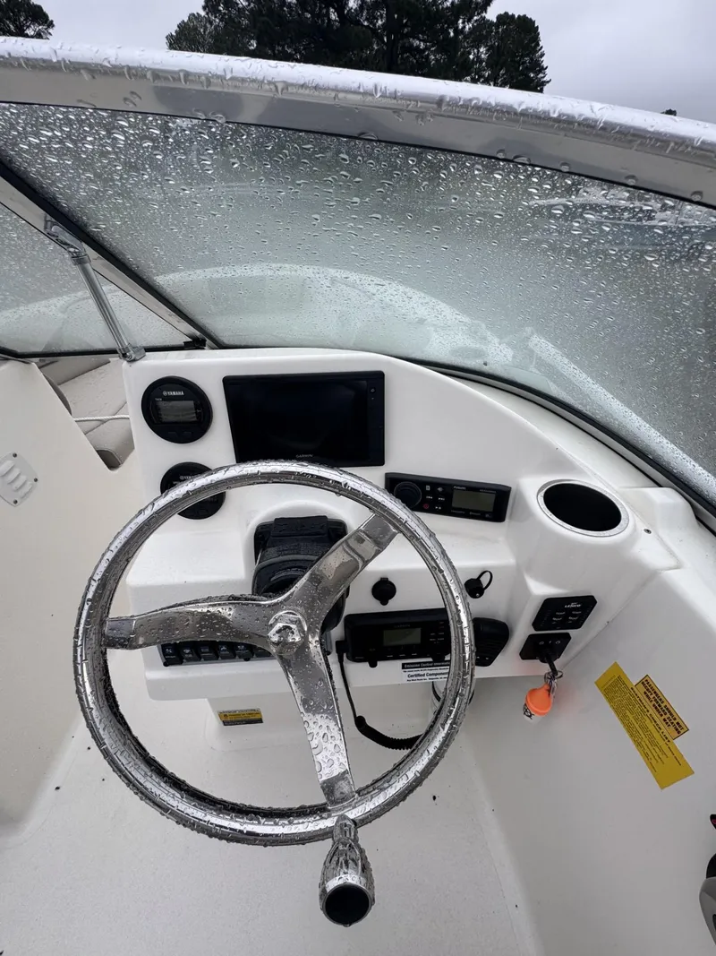 Slide: The Image of 2021 Key West 203 DFS boat dashboard with steering wheel and control panel. - 5
