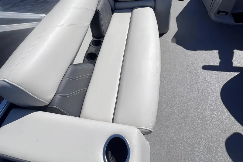 Slide: The Image of 2022 Sylvan Mirage 820 PARTY FISH boat interior with white cushioned seating and cup holders. - 11