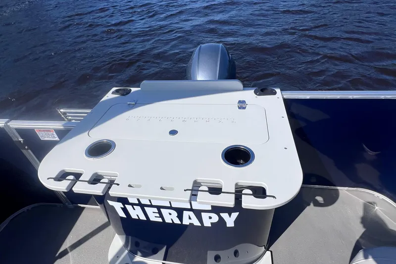 Slide: The Image of 2022 Sylvan Mirage 820 PARTY FISH boat with table, cup holders, and "THERAPY" text. - 17