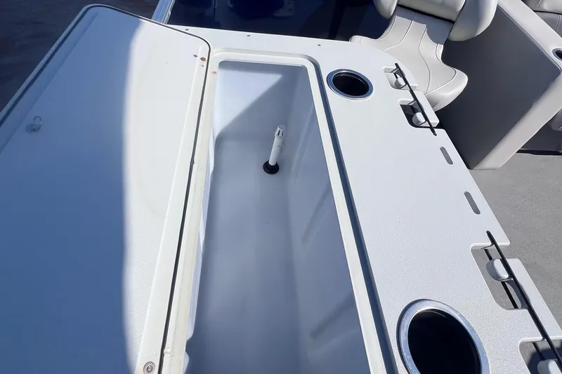 Slide: The Image of 2022 Sylvan Mirage 820 PARTY FISH boat interior with storage compartment and cup holders. - 18