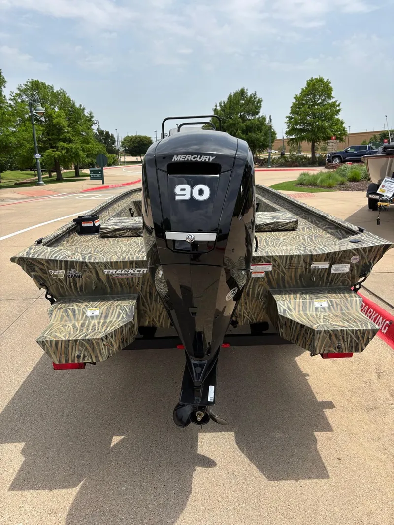 Slide: The Image of 2025 Tracker Grizzly 1860 CC boat with Mercury 90 engine, parked outdoors. - 3