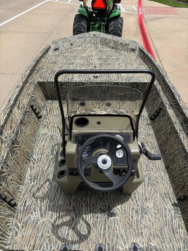 Slide: The Image of 2025 Tracker Grizzly 1860 CC boat with camouflage design and steering console. - 4