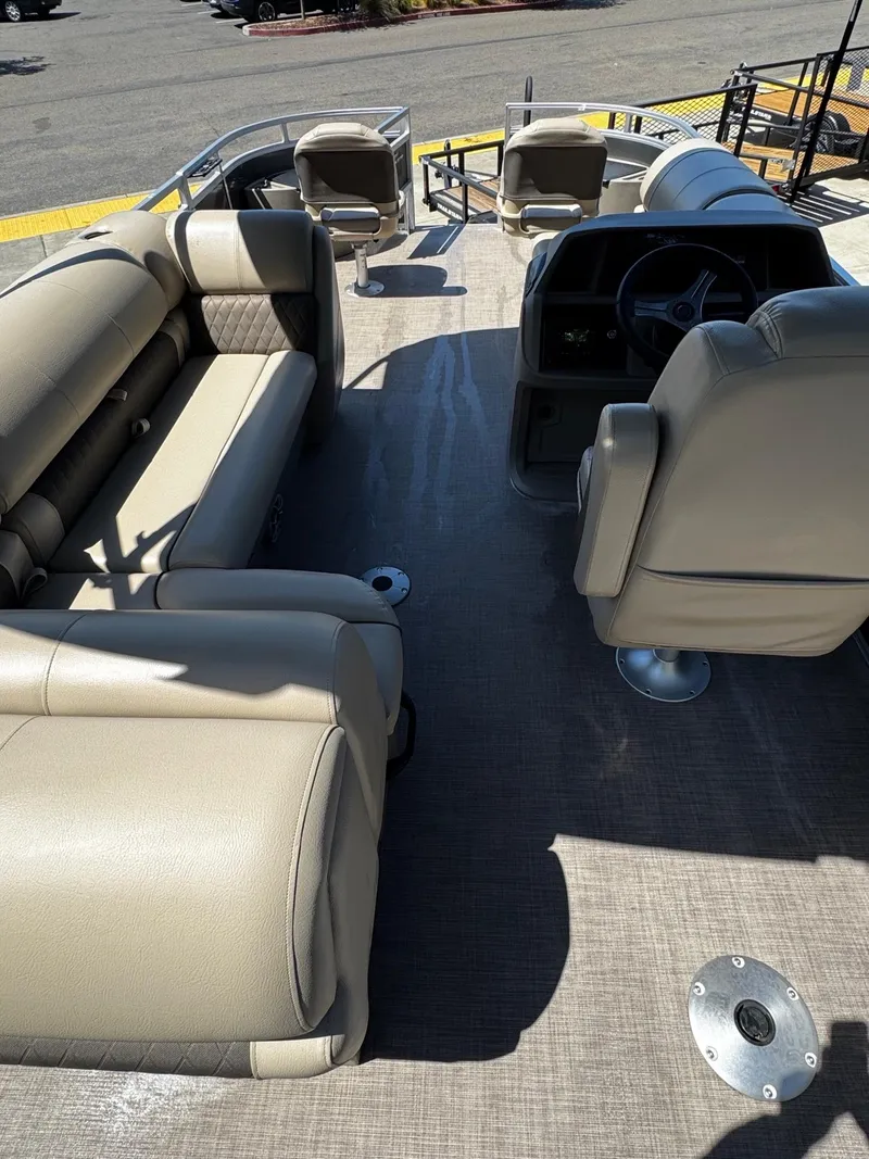Slide: The Image of 2025 Sun Tracker Fishin' Barge 20 DLX interior with beige seating and steering console. - 6