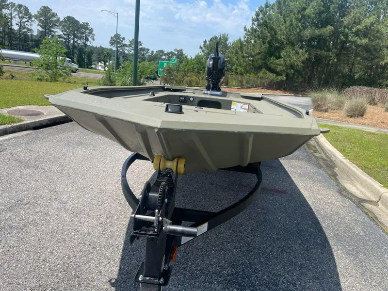Slide: The Image of 2025 Tracker Grizzly 1654 T Sportsman boat on trailer, parked on a sunny day. - 4
