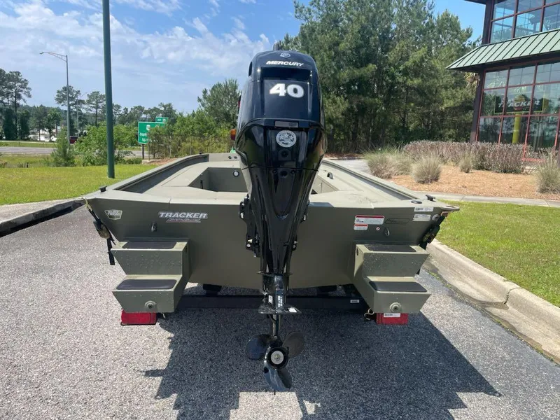 Slide: The Image of 2025 Tracker Grizzly 1654 T Sportsman boat with Mercury 40 engine, parked outdoors. - 5