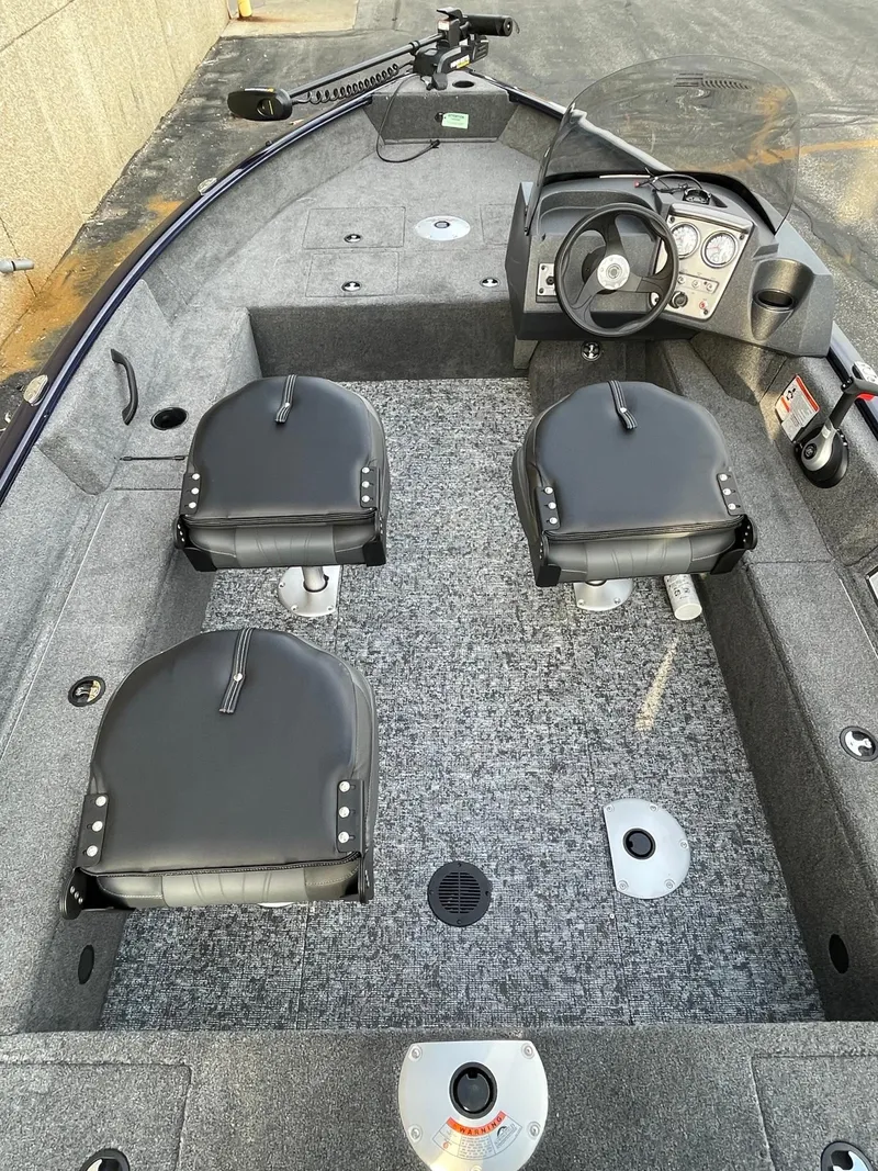 Slide: The Image of 2025 Tracker Pro Guide V-16 SC boat interior with three seats and steering console. - 3