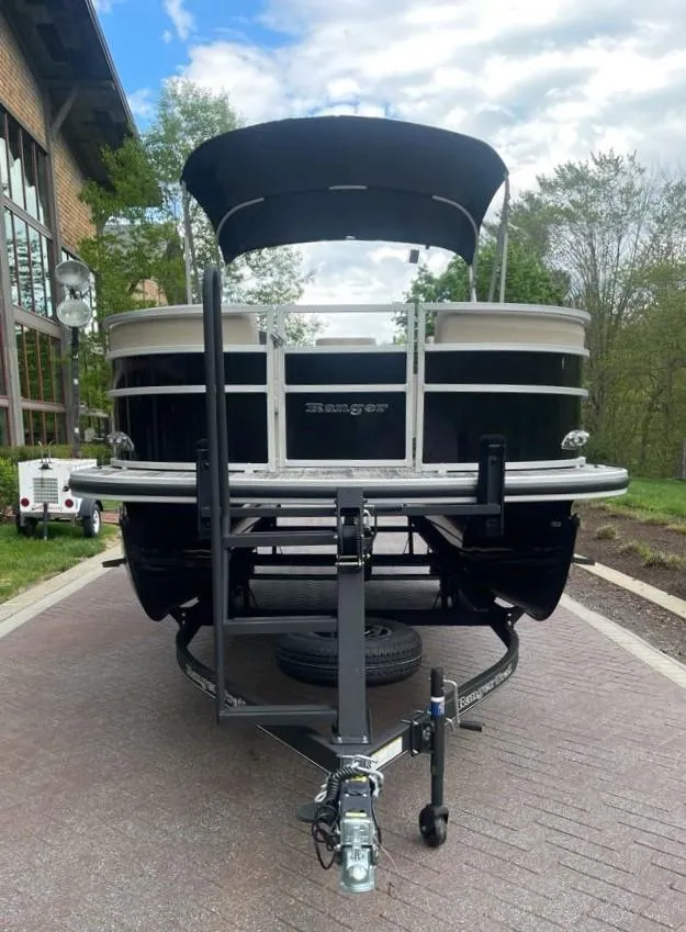Slide: The Image of 2025 Ranger Reata 220C pontoon boat on trailer, parked outdoors. - 3