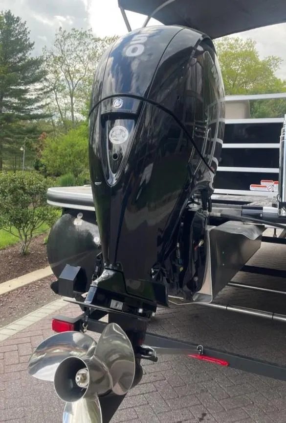 Slide: The Image of 2025 Ranger Reata 220C boat with powerful outboard motor, parked on a paved surface. - 8