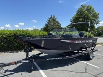Slide: The Image of 2025 Tracker Pro Guide V-175 Combo boat on trailer in sunny parking lot. - 2