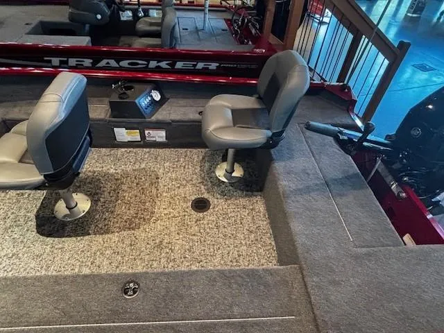 Slide: The Image of 2025 Tracker Super Guide V-16 T boat interior with two swivel seats and carpeted flooring. - 4