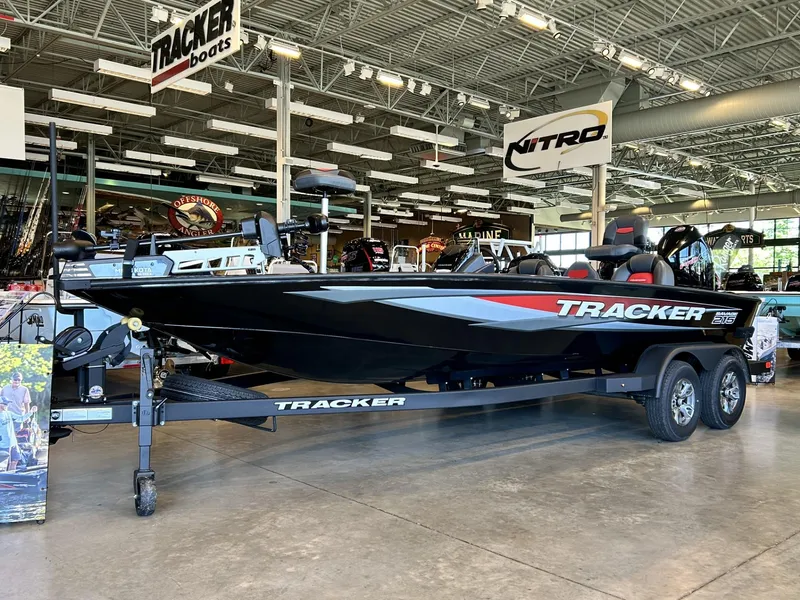 The Image of 2025 Tracker Savage 215 boat displayed in showroom, featuring sleek black design and modern features. - 0
