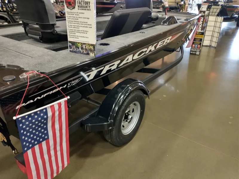 Slide: The Image of 2025 Tracker Panfish 17 boat on display with American flag and warranty sign. - 2