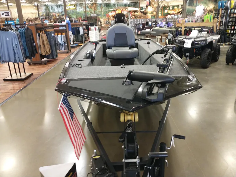 Slide: The Image of 2025 Tracker Panfish 17 boat displayed indoors with American flag, surrounded by outdoor gear. - 3