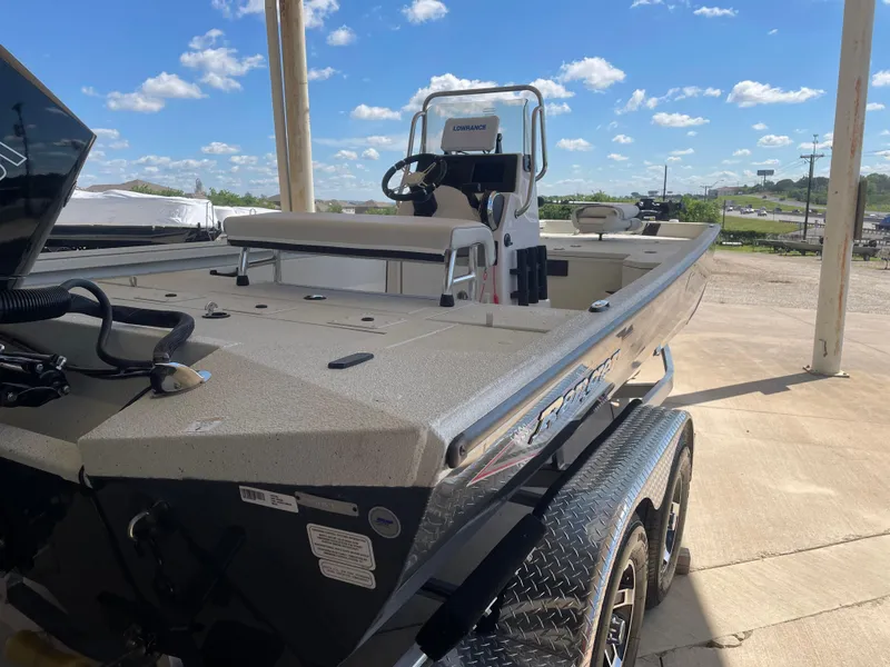 Slide: The Image of 2025 Ranger RB210 boat on trailer under sunny sky, showcasing sleek design and spacious deck. - 8