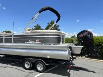 Slide: The Image of 2025 Sun Tracker Party Barge 22 DLX pontoon boat on trailer, parked outdoors. - 3