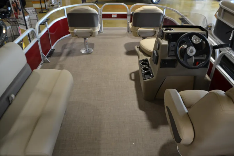 Slide: The Image of 2025 Sun Tracker Bass Buggy 16 XL Select pontoon boat interior with beige seating and steering console. - 2