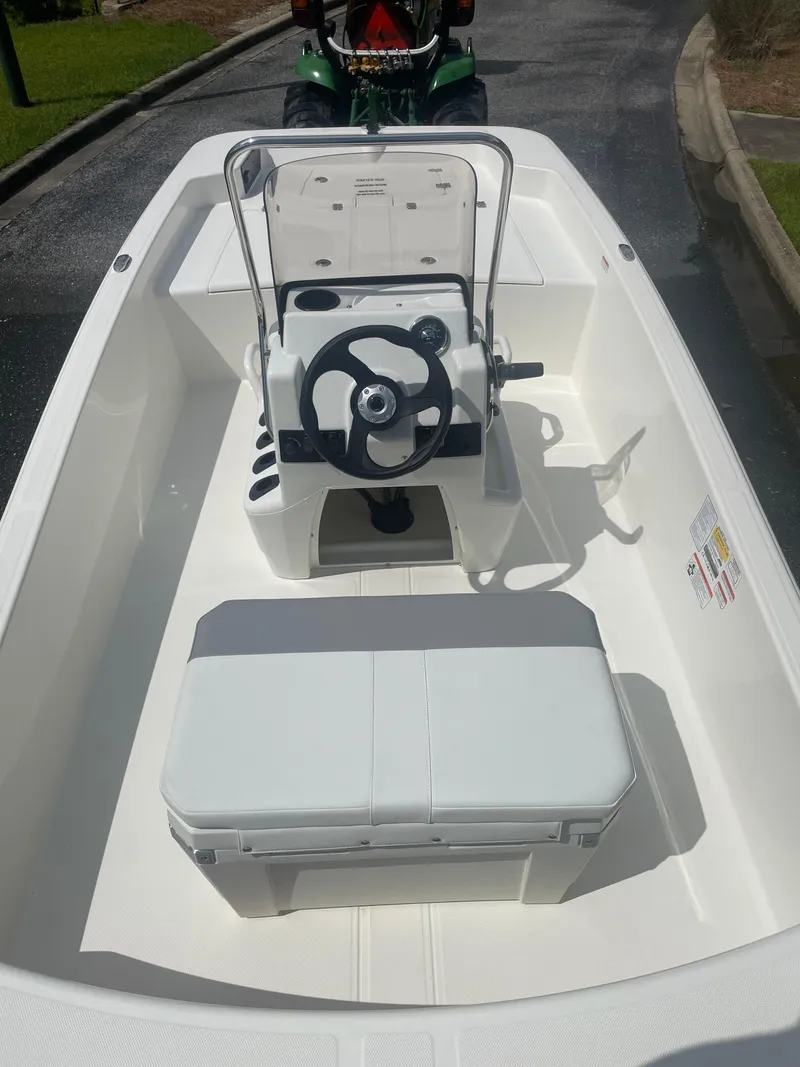 Slide: The Image of 2025 Mako Pro Skiff 15 CC boat interior with steering console and seating. - 2