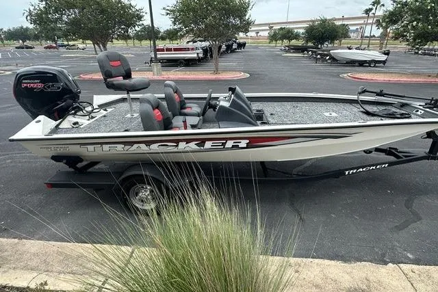 Slide: The Image of 2025 Tracker Pro Team 190 boat in parking lot, side view with seating and motor. - 3
