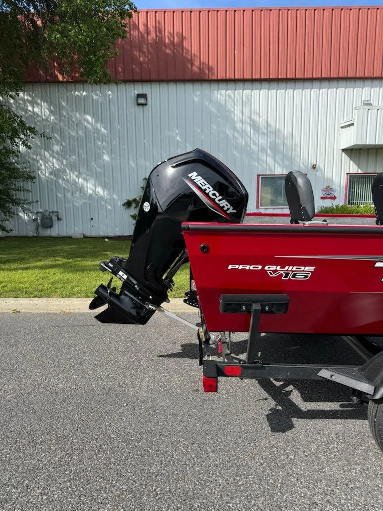 Slide: The Image of 2025 Tracker Pro Guide V-16 WT boat with Mercury outboard motor, parked outdoors. - 4