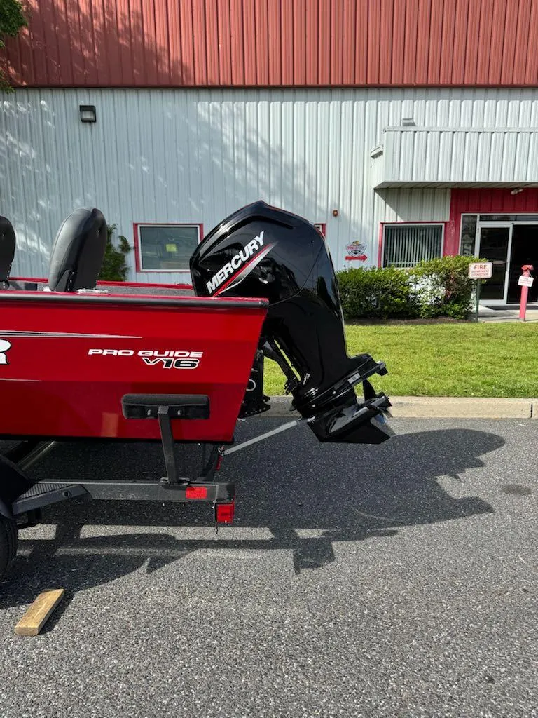 Slide: The Image of 2025 Tracker Pro Guide V-16 WT boat with Mercury outboard motor, parked outdoors. - 5