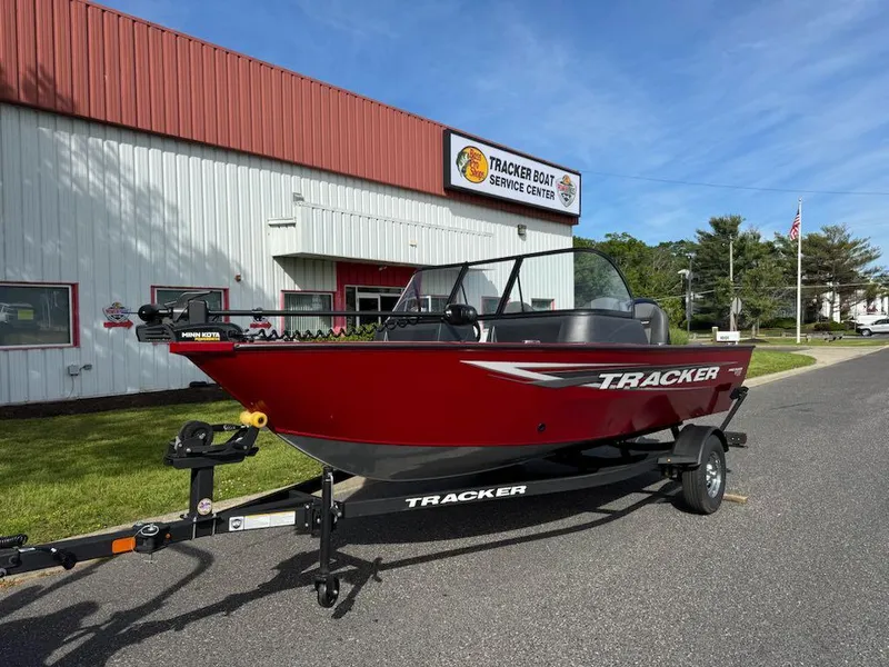 Slide: The Image of 2025 Tracker Pro Guide V-16 WT boat on trailer outside service center. - 6