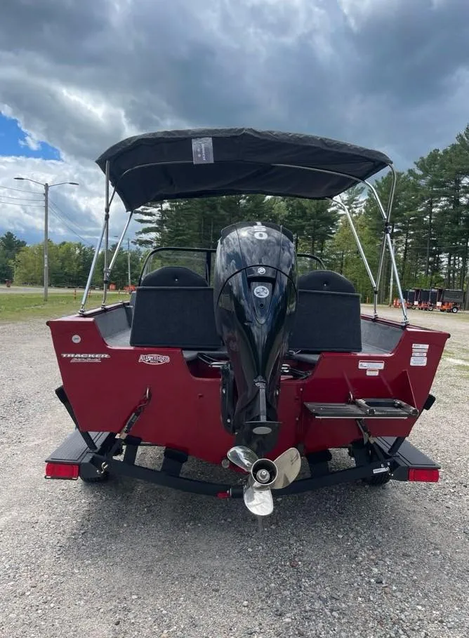 Slide: The Image of 2025 Tracker Pro Guide V-175 Combo boat, rear view, parked outdoors under cloudy sky. - 5