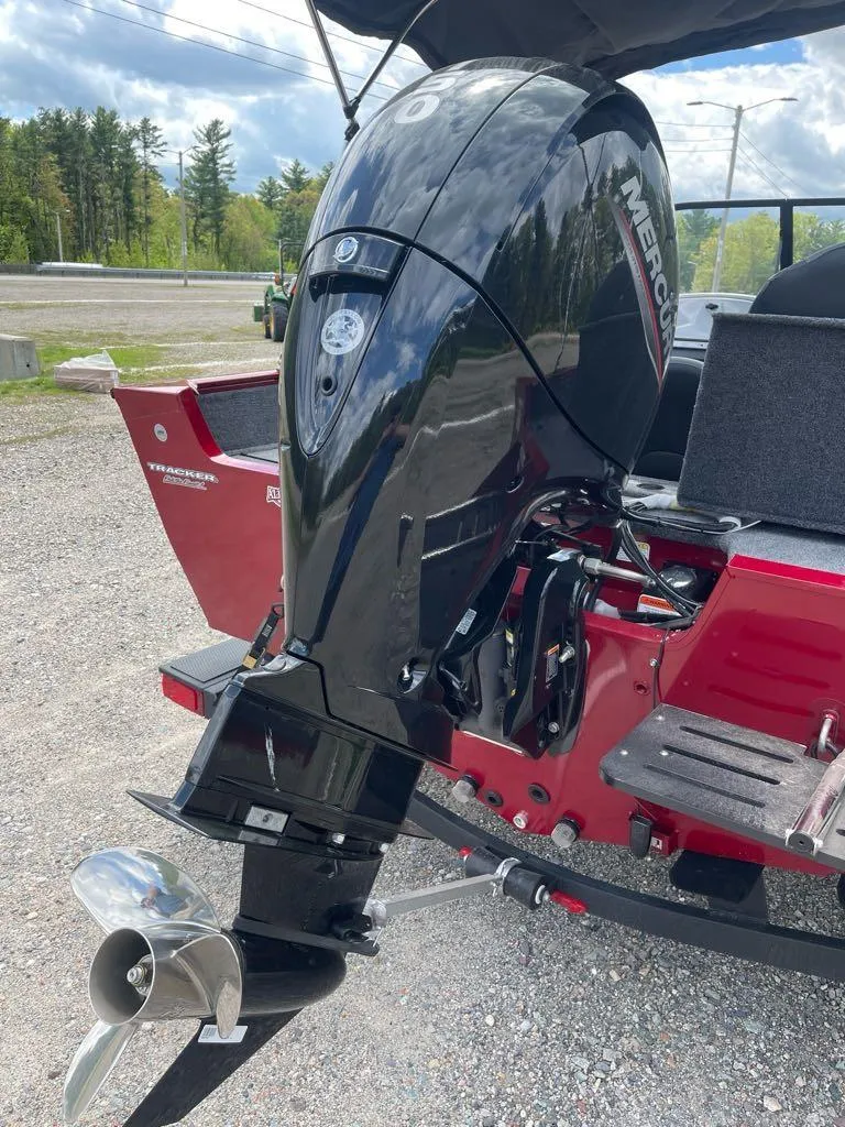 Slide: The Image of 2025 Tracker Pro Guide V-175 Combo boat with Mercury outboard motor, parked outdoors. - 6