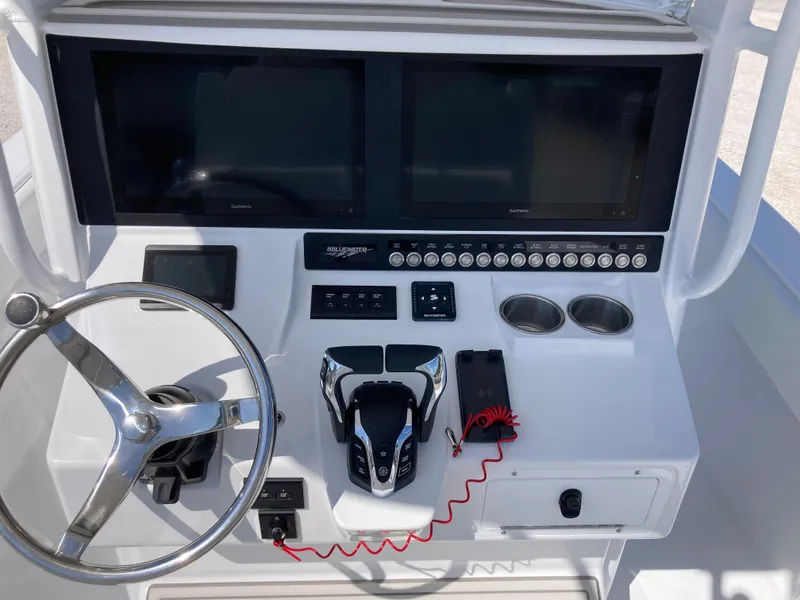 Slide: The Image of Control panel of 2025 Bluewater II25T boat with steering wheel and electronic displays. - 10