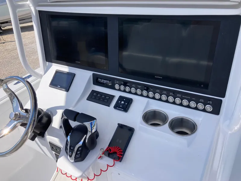 Slide: The Image of Control panel of 2025 Bluewater II25T boat with dual screens and steering wheel. - 11