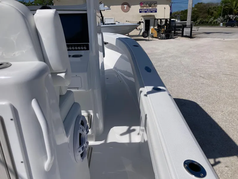 Slide: The Image of 2025 Bluewater II25T boat interior with modern console and seating in a sunny outdoor setting. - 13