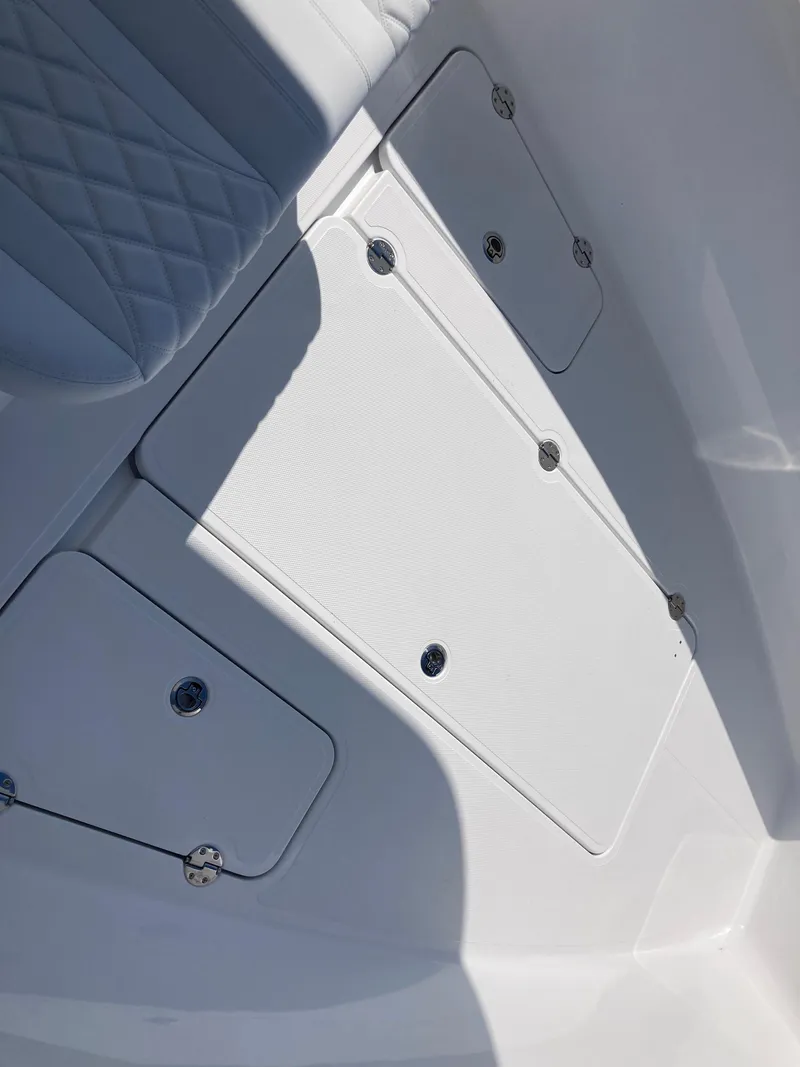 Slide: The Image of 2025 Bluewater II25T boat deck with storage compartments and cushioned seating. - 16