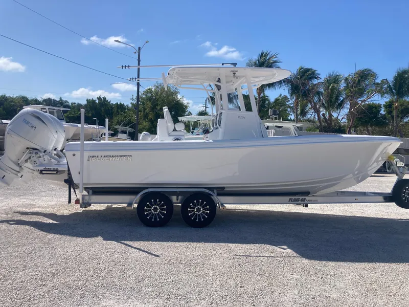 Slide: The Image of 2025 Bluewater II25T boat on trailer, parked outdoors under clear sky. - 2