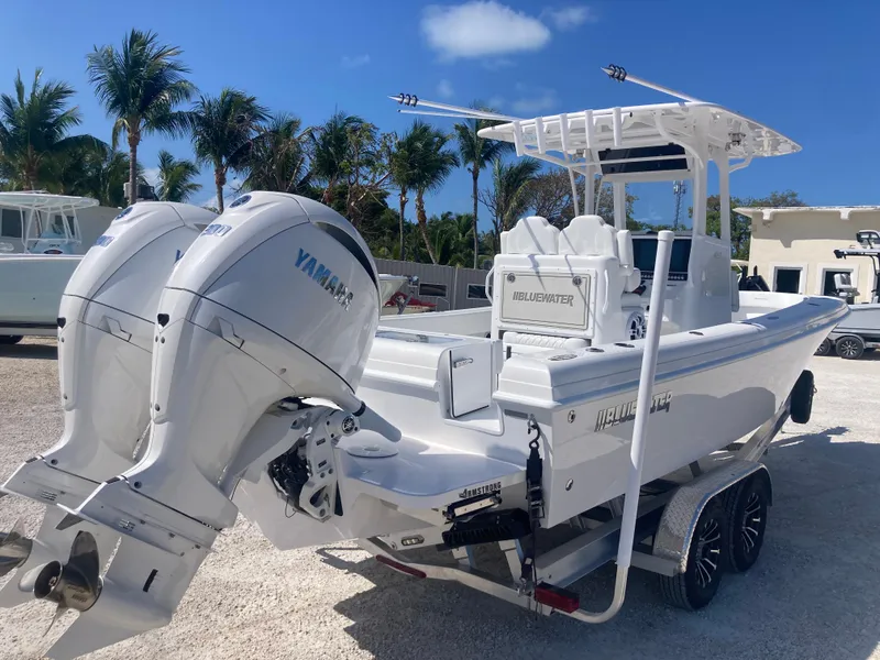 Slide: The Image of 2025 Bluewater II25T boat with dual Yamaha engines, parked on a trailer, surrounded by palm trees. - 3