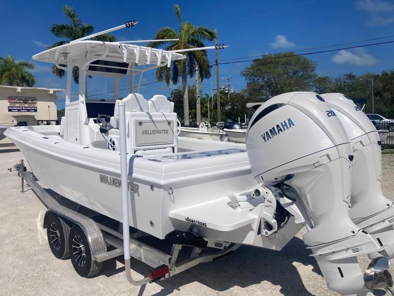 Slide: The Image of 2025 Bluewater II25T boat with Yamaha engine, parked on a trailer under a clear blue sky. - 4