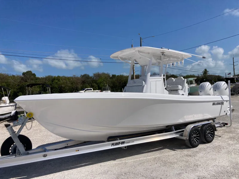 Slide: The Image of 2025 Bluewater II25T boat on trailer, sleek white design, dual engines, ready for adventure. - 5