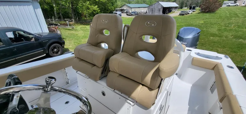 Slide: The Image of 2017 Sportsman Open 282 Center Console boat with tan cushioned seats and steering wheel. - 15