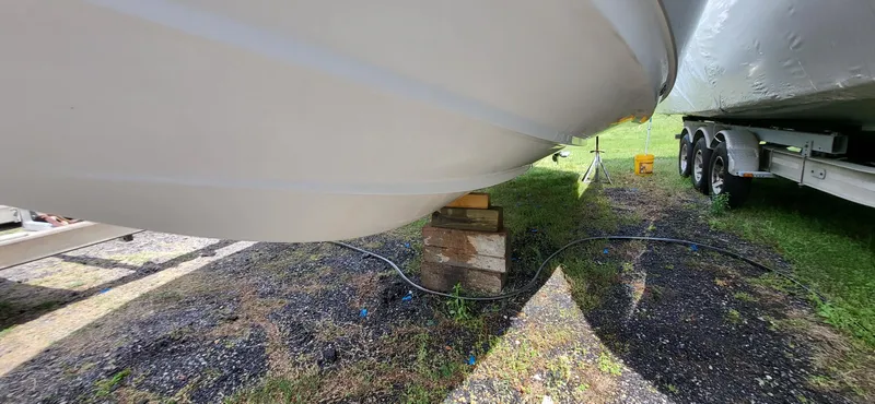 Slide: The Image of 2017 Sportsman Open 282 Center Console boat hull on blocks, parked on grass. - 16