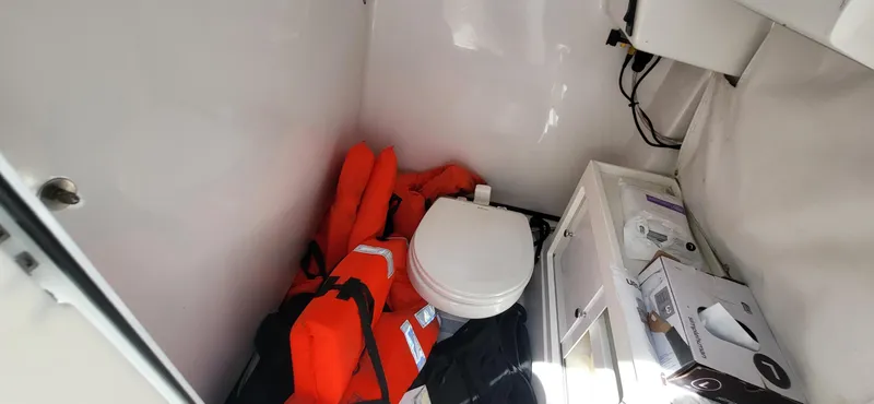 Slide: The Image of 2017 Sportsman Open 282 Center Console interior with life jackets and marine toilet. - 18