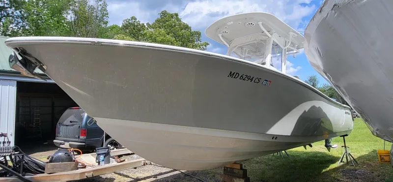 Slide: The Image of 2017 Sportsman Open 282 Center Console boat on trailer, parked outdoors. - 2