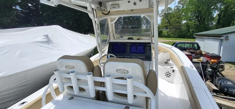 Slide: The Image of 2017 Sportsman Open 282 Center Console boat with dual screens and seating, docked outdoors. - 7